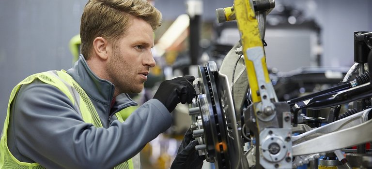 Ingenieur prüft Autoteil in Produktionshalle