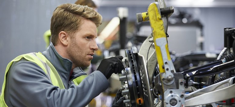 Ingenieur prüft Autoteil in Produktionshalle