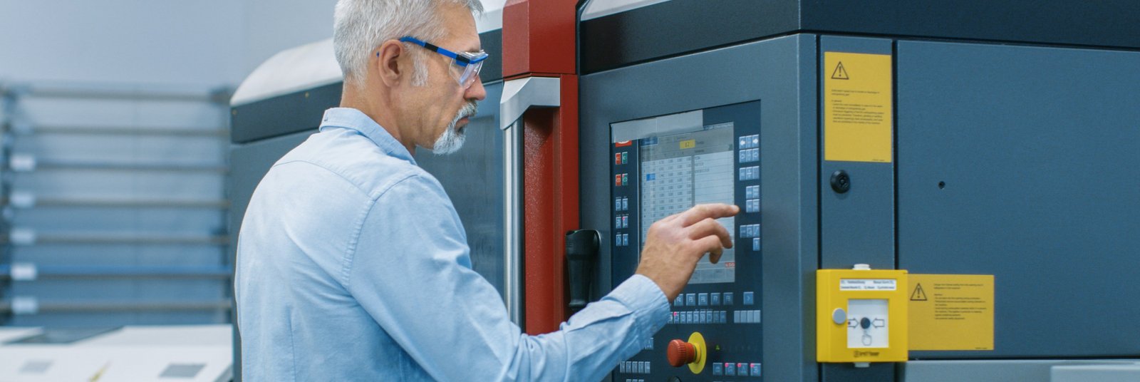 Ingenieur bedient Kontrollpanel an CNC-Maschine